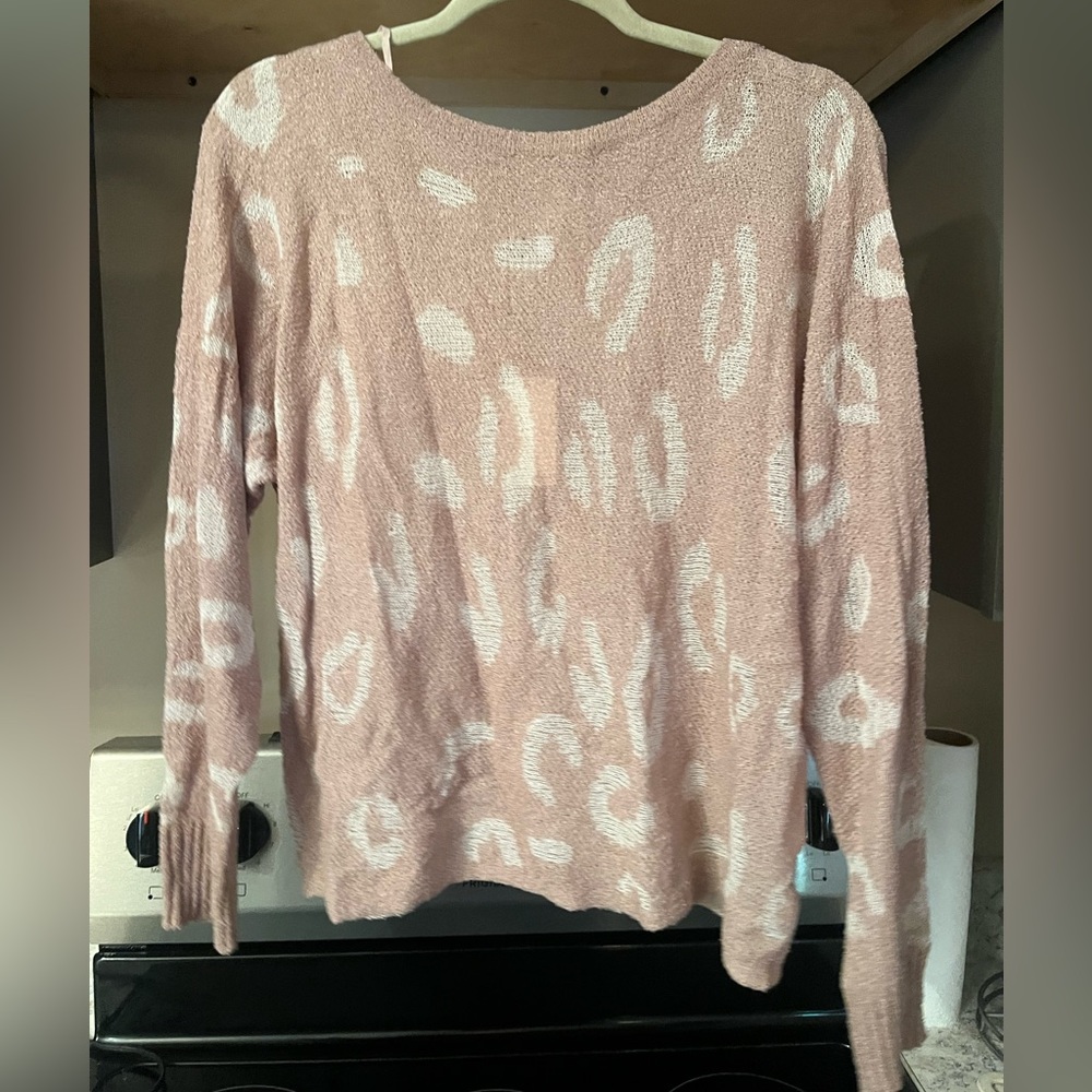 Pink sweater with white leopard spots.